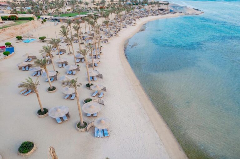 Vue aérienne de la plage du Blend Elphistone Resort, avec ses palmiers, ses parasols de paille et la mer turquoise
