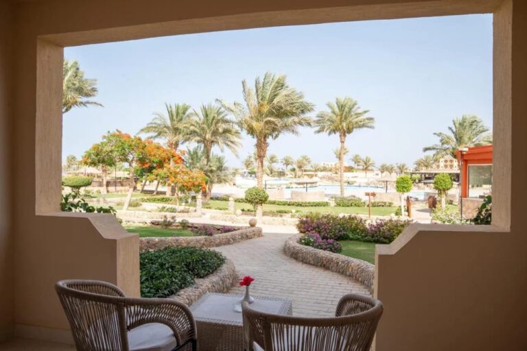 Une terrasse avec deux fauteuils tressés, face aux jardins fleuris et aux palmiers du Blend Elphistone Resort