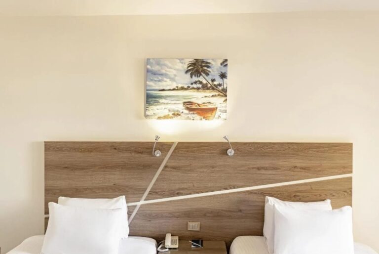 Une tête de lit en bois sous un tableau de barque sur la plage