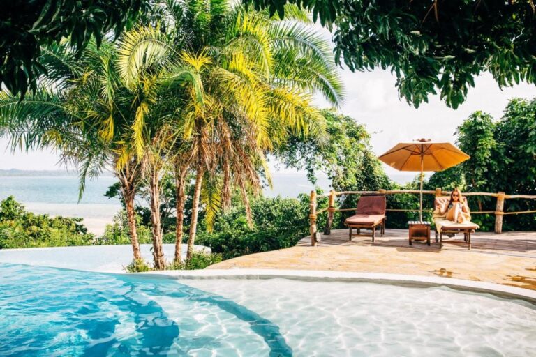 La piscine à débordement, ses transats et son parasol orange, face à la mer
