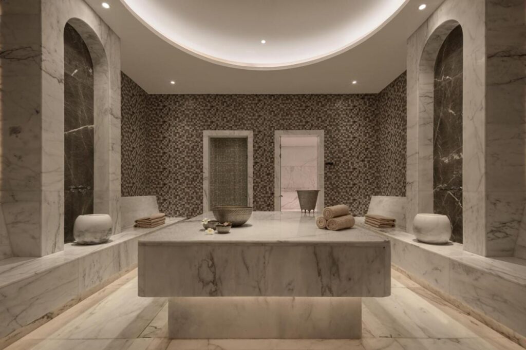 Une salle du spa du JAZ Elite Riviera habillée de marbre, avec une large table de pierre au centre