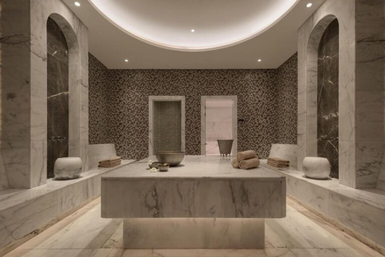 Une salle du spa du JAZ Elite Riviera habillée de marbre, avec une large table de pierre au centre