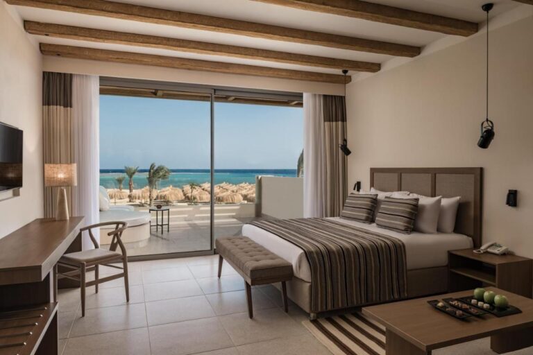 Une chambre au grand lit avec un balcon face à la mer Rouge
