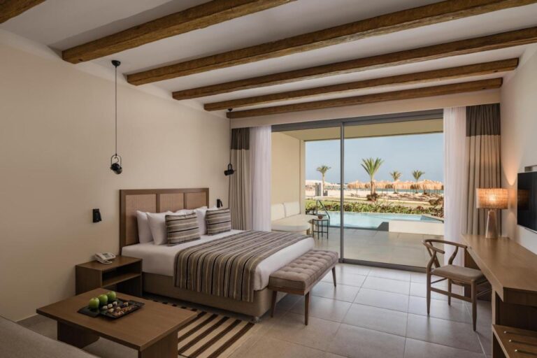 Une chambre au grand lit ouverte sur une piscine