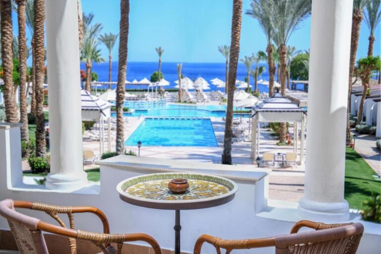 La vue depuis une terrasse du JAZ Fanara Resort sur les piscines, les palmiers et la mer Rouge