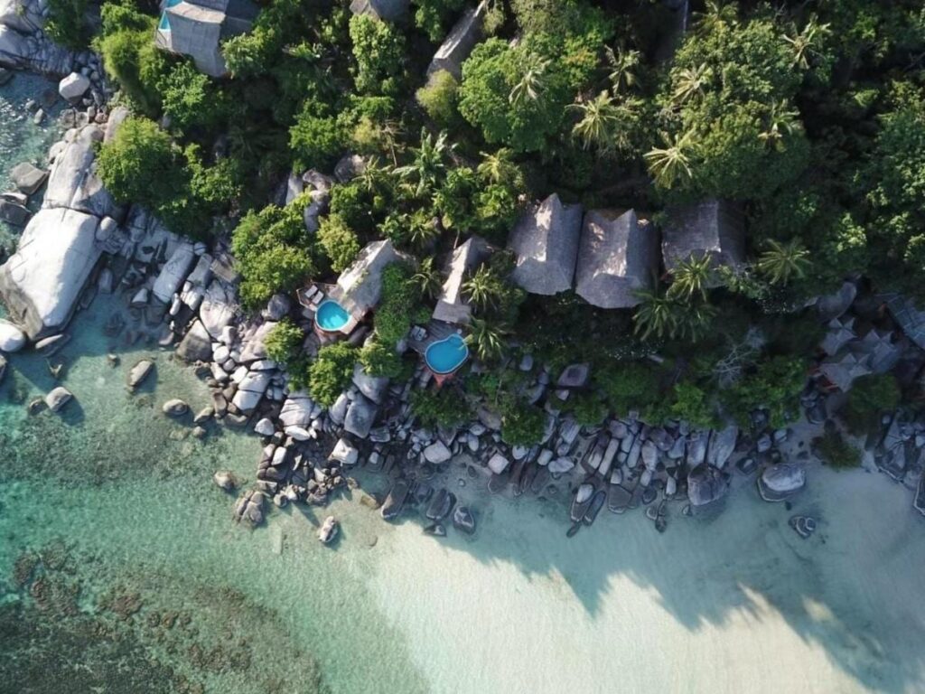 Vue aérienne du Koh Tao Cabana, ses cottages parmi les arbres, ses rochers et sa plage de sable blanc