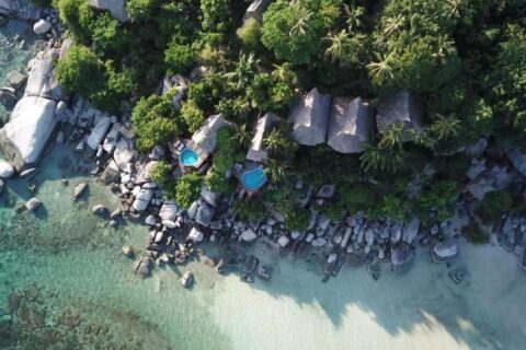 Vue aérienne du Koh Tao Cabana, ses cottages parmi les arbres, ses rochers et sa plage de sable blanc