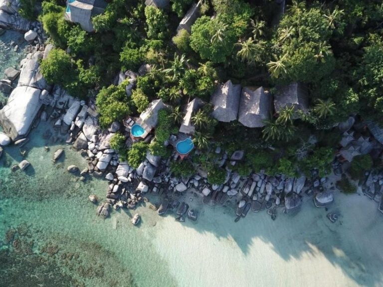 Vue aérienne du Koh Tao Cabana, ses cottages parmi les arbres, ses rochers et sa plage de sable blanc