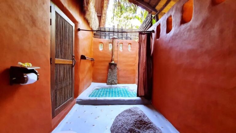 La douche semi-ouverte d'un cottage, avec un rideau et un sol en mosaïque turquoise
