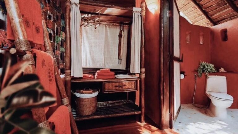 Une penderie, des serviettes orange et des toilettes aux murs rouges