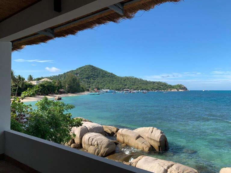 La baie et ses rochers vus d'une terrasse couverte du Koh Tao Heritage, avec des bateaux au mouillage