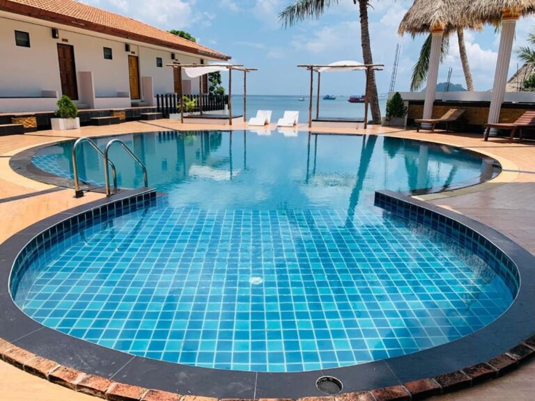 La piscine aux carreaux bleus, avec la mer et des bateaux au fond