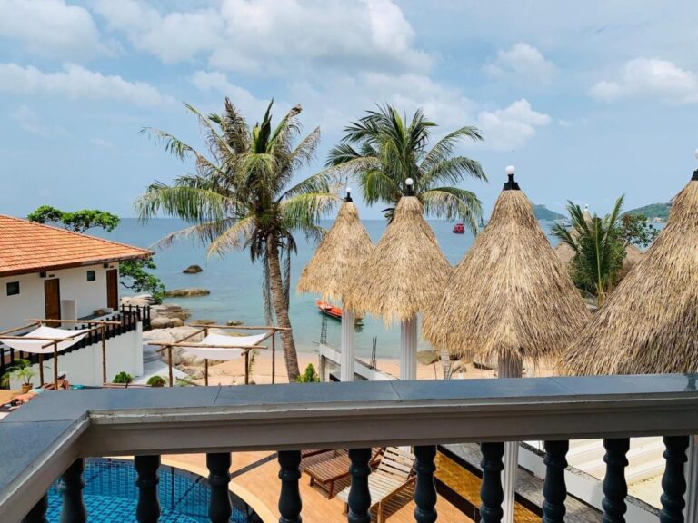 Vue d'un balcon sur les parasols de paille, les palmiers et la mer