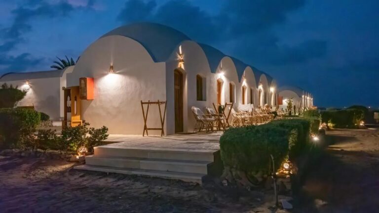 Les chalets du Marsa Shagra Village éclairés à la nuit tombée, avec leurs terrasses