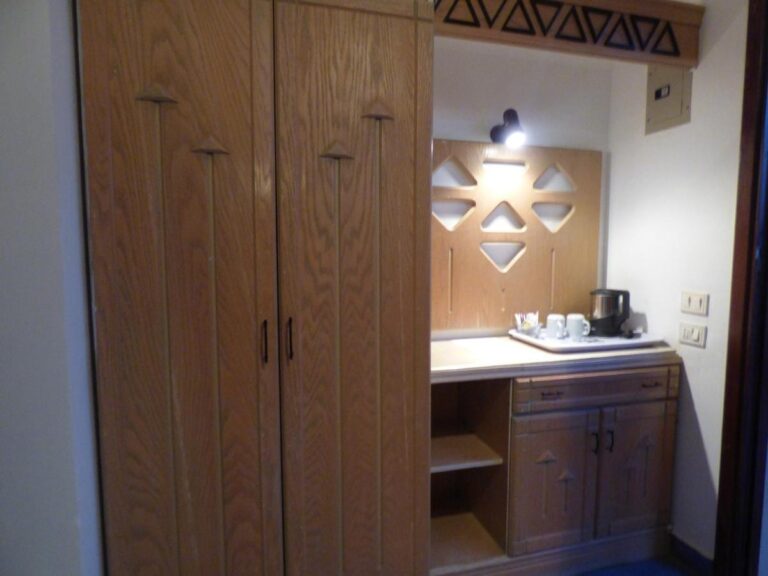 Une grande armoire en bois et un meuble avec une bouilloire et des tasses