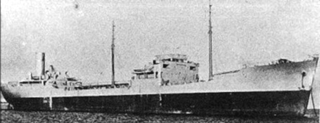 Photo d'archive en noir et blanc, granuleuse, d'un pétrolier vu de profil, avec sa passerelle au centre, deux mâts et sa cheminée à l'arrière.