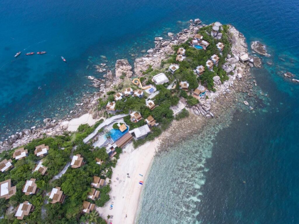 Vue aérienne du Sai Daeng Resort, ses bungalows sur une pointe rocheuse, ses piscines et sa plage de sable