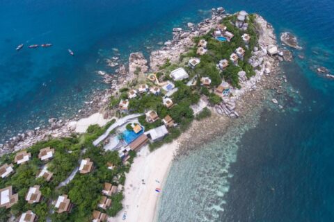 Vue aérienne du Sai Daeng Resort, ses bungalows sur une pointe rocheuse, ses piscines et sa plage de sable