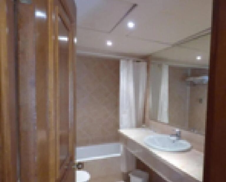 Une salle de bains avec baignoire, rideau de douche et long plan de toilette