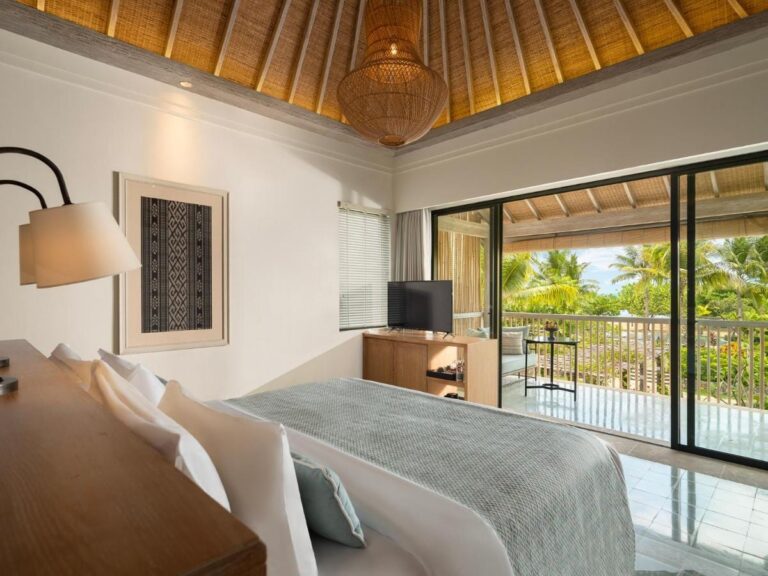 Une chambre ouverte sur un balcon, avec vue sur les palmiers