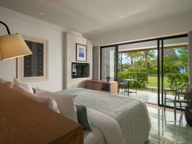 Une chambre au grand lit ouverte sur la terrasse et le jardin