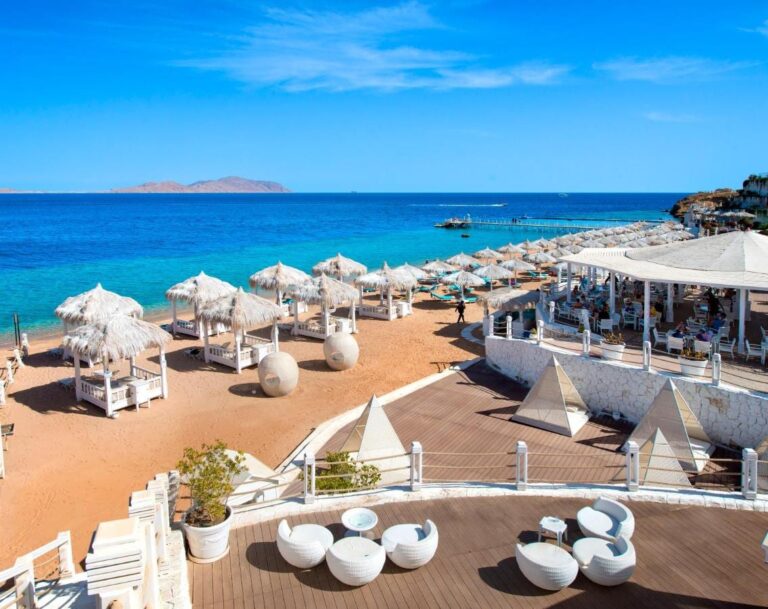 La plage du Sunrise Arabian Beach Resort, ses parasols de paille et son ponton, face à l'île de Tiran