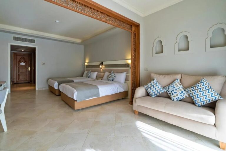 Une chambre à deux lits, avec un canapé et des niches en forme d'arche dans le mur