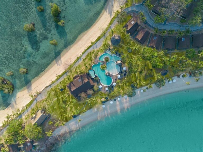 Vue du ciel de la piscine et des toits du resort, entre deux plages de sable