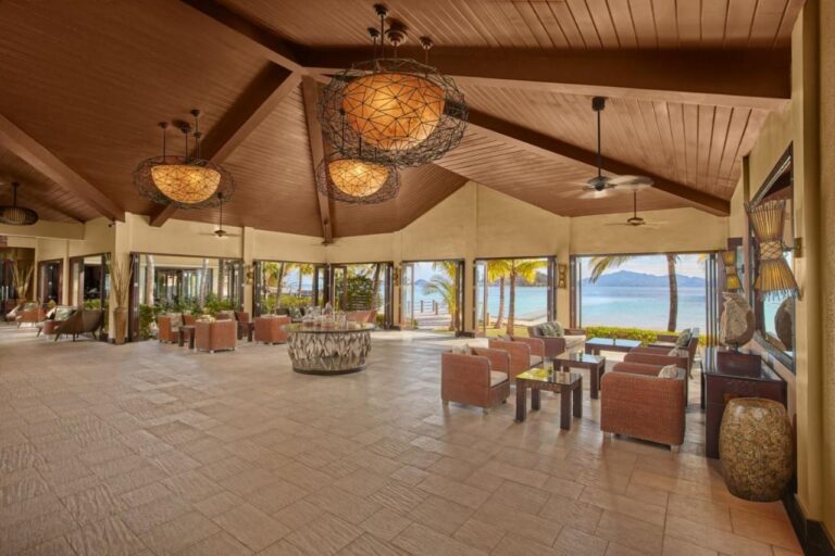 Le hall du Two Seasons Coron, ouvert sur la plage, avec ses fauteuils tressés et ses grandes suspensions